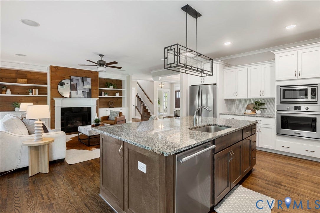 6984 Carden Park Drive, Moseley, VA 23120 Kitchen featuring an oversized large honed granite-topped island with integrated sink, seating and storage, white shaker cabinetry, a herringbone tile backsplash, stainless steel appliances.