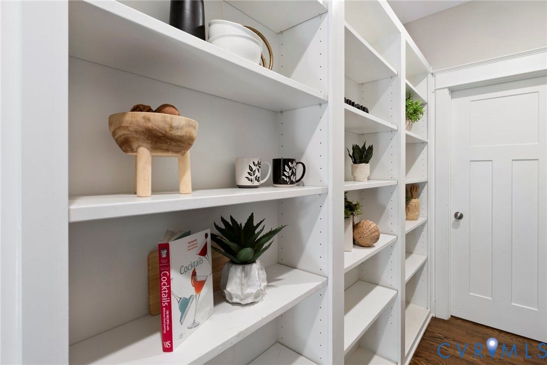 6984 Carden Park Drive, Moseley, VA 23120 Walk through panty, White built-in shelving with adjustable shelves, hardwood-finish flooring, and built in desk.