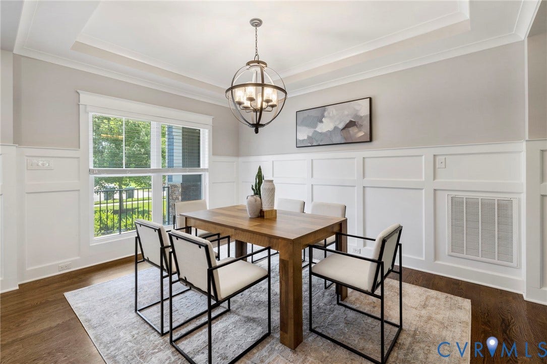 6984 Carden Park Drive, Moseley, VA 23120 Open-concept living and dining areas featuring site finished hard wood-flooring, white wainscoting, and tray ceilings.