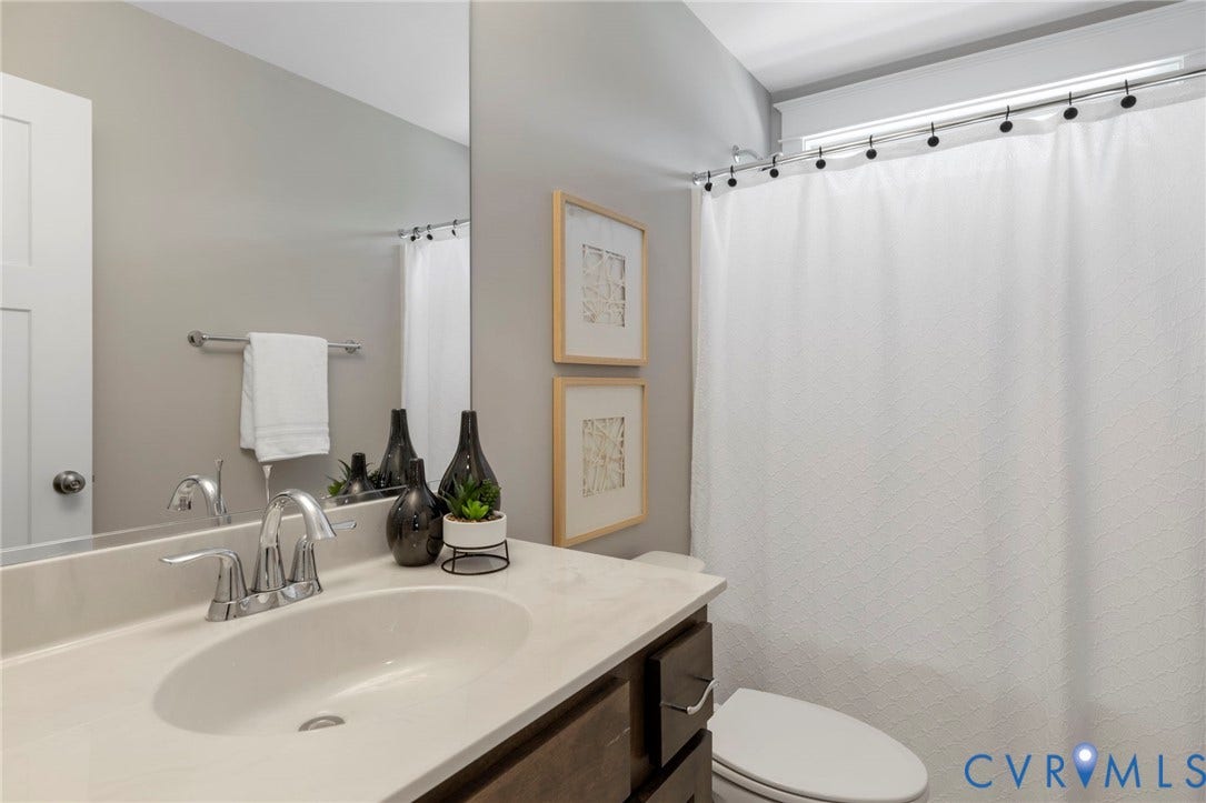 6984 Carden Park Drive, Moseley, VA 23120 Bathroom vanity featuring an integrated sink, polished chrome faucet, and wood-finish cabinetry