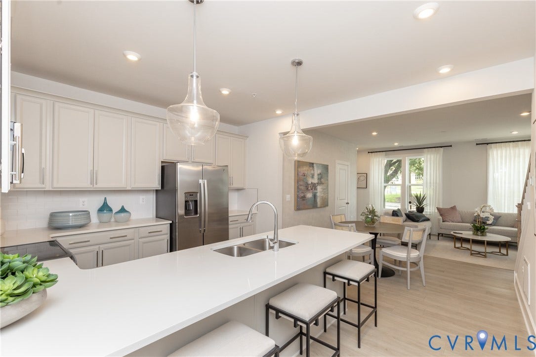 1041 N Lombardy Street, #A, Carver Square, Richmond, VA 23220 Contemporary kitchen featuring a large island with a double basin sink, light-colored cabinetry, stainless steel appliances, and pendant lighting