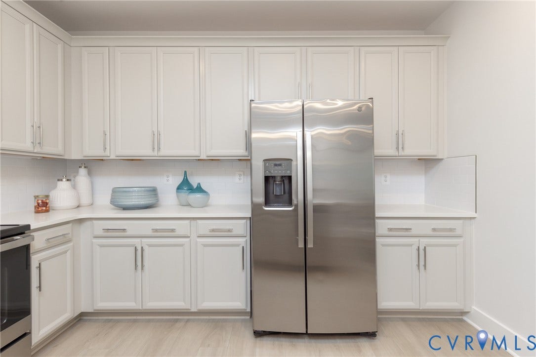 1041 N Lombardy Street, #A, Carver Square, Richmond, VA 23220 Modern kitchen featuring extensive white cabinetry with brushed nickel hardware, white countertops, & a white subway tile backsplash.