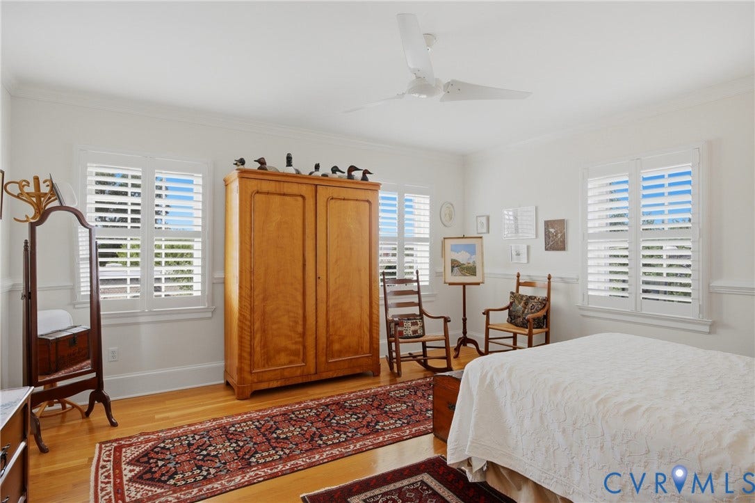 Bright room featuring wood-finish flooring, white walls with wainscoting, and crown molding