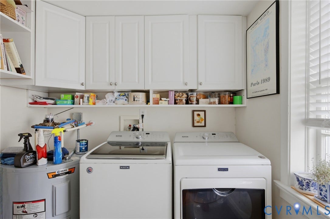 Dedicated utility area featuring white cabinetry, open shelving, and a window with blinds