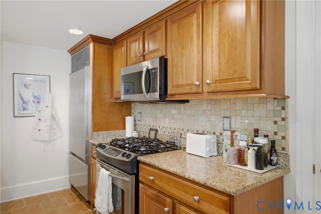 Kitchen featuring wood cabinetry, stainless steel appliances, speckled countertops, a mosaic tile backsplash, and recessed lighting