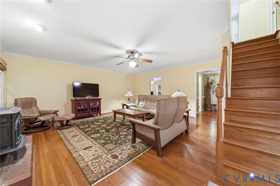 1902 Soldiers Lane, Crozier, VA 23039 Warm living space featuring hardwood flooring, a ceiling fan with integrated lighting, and crown molding