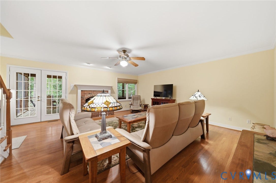 1902 Soldiers Lane, Crozier, VA 23039 Living space featuring wood-finish flooring, a brick fireplace with a white mantel, and white French doors