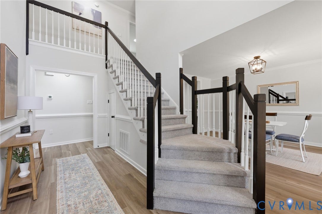 3457 Richards Run, Very Desirable!, Powhatan, VA 23139 Two-story foyer with a carpeted staircase featuring dark wood newel posts and handrails, white balusters, and light wood-finish flooring