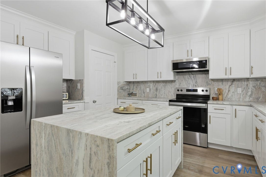 3457 Richards Run, Very Desirable!, Powhatan, VA 23139 Kitchen featuring a central island with a waterfall edge, white cabinetry with gold-tone hardware, and stainless steel appliances