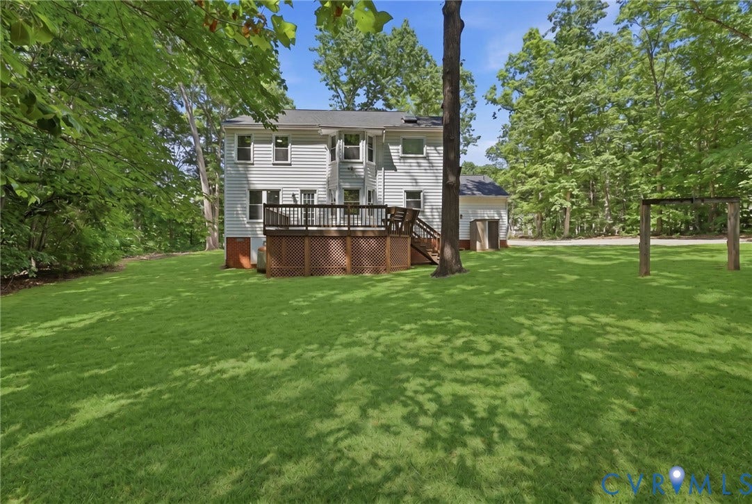 3457 Richards Run, Very Desirable!, Powhatan, VA 23139 Spacious backyard featuring a large wood-finish deck with lattice skirting, expansive green lawn, mature trees, and a detached structure