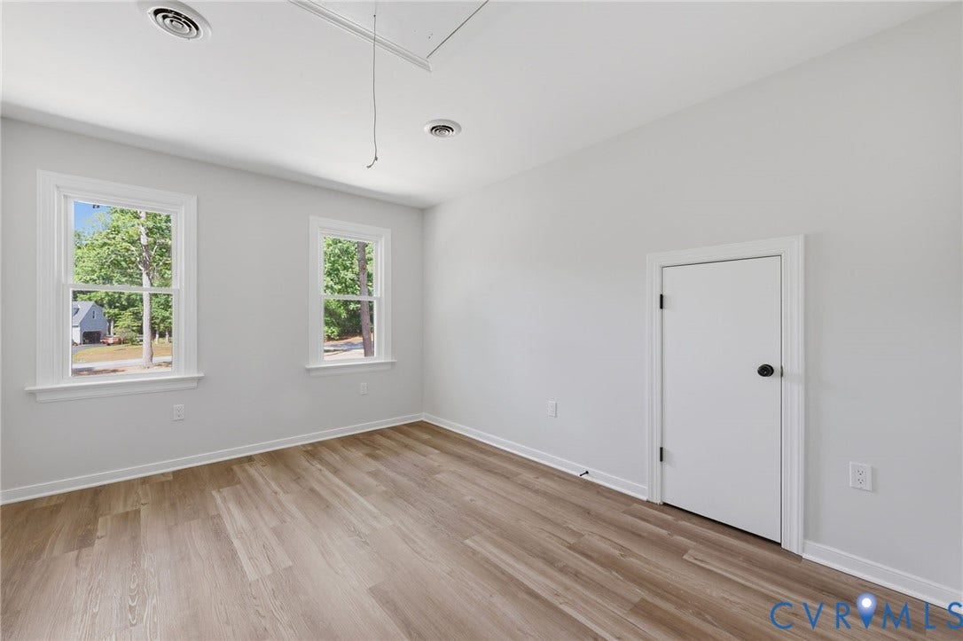 3457 Richards Run, Very Desirable!, Powhatan, VA 23139 Spacious room featuring wood-finish flooring, two large windows with white trim, white walls, and a white interior door with a black knob