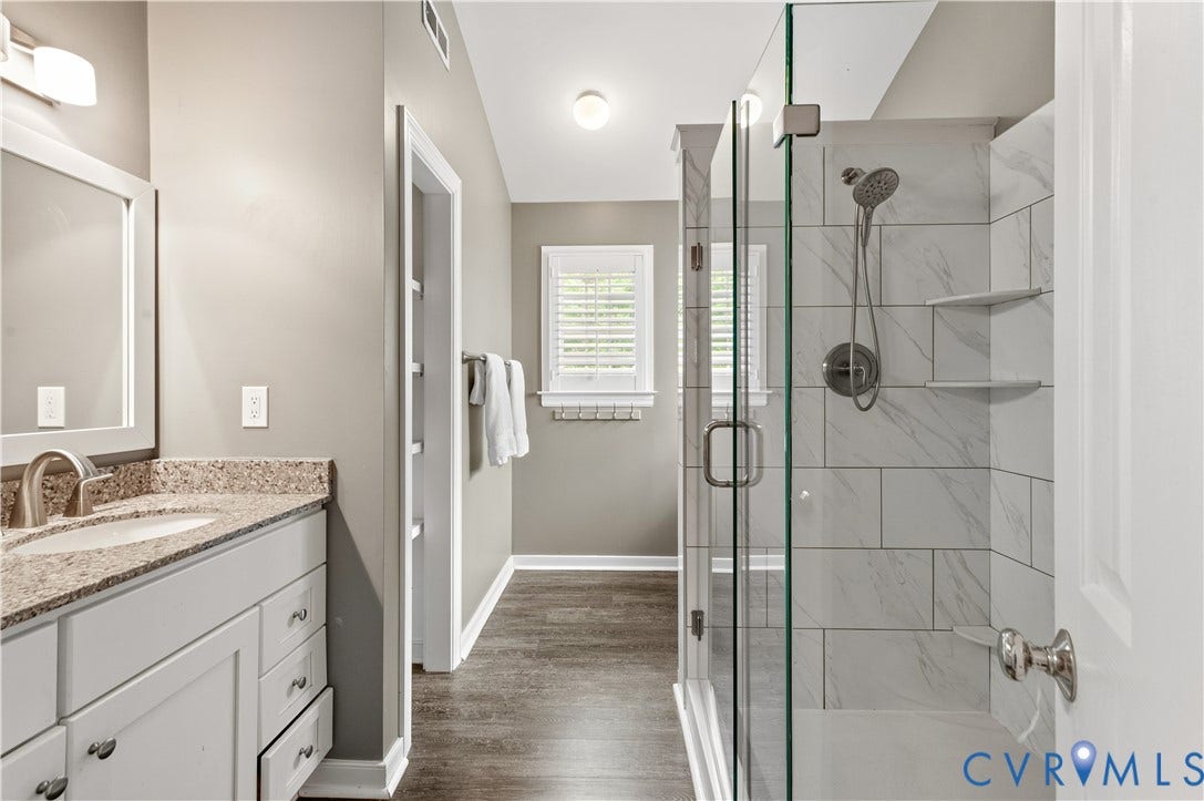 5117 Hart Mill Drive, Glen Allen, VA 23060 Shower with glass enclosure and white subway tile surround, featuring a built-in bench and recessed shelving