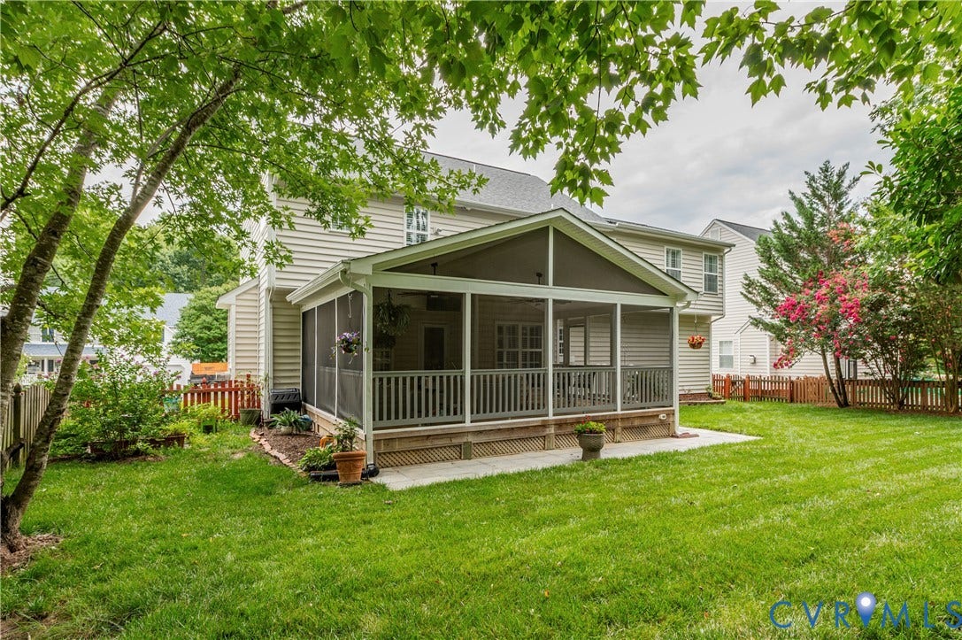 5117 Hart Mill Drive, Glen Allen, VA 23060 Rear exterior featuring a screened porch with a gabled roofline, light-toned siding, a concrete patio, a manicured lawn, and mature trees