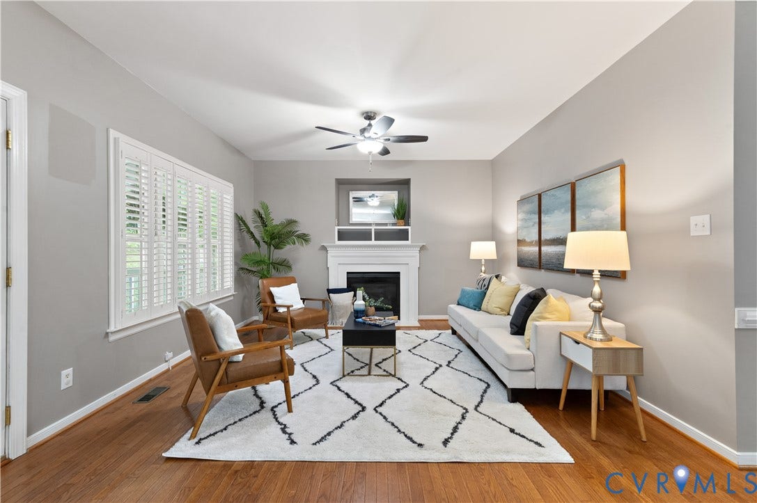 5117 Hart Mill Drive, Glen Allen, VA 23060 Living room featuring wood-finish flooring, white plantation shutters, a white fireplace with mantle, and a ceiling fan with light fixture