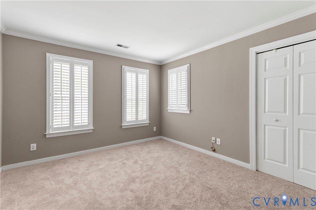 5117 Hart Mill Drive, Glen Allen, VA 23060 Carpeted room featuring two windows with white plantation shutters, a white bi-fold closet, crown molding, and neutral wall tones