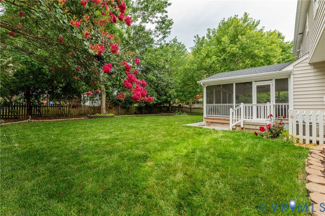 5117 Hart Mill Drive, Glen Allen, VA 23060 Expansive green lawn with mature flowering trees, a picket fence, and a screened-in porch with white railings and a white storm door