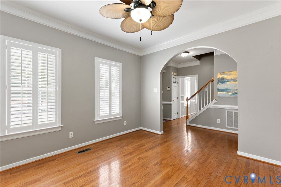 5117 Hart Mill Drive, Glen Allen, VA 23060 Spacious room featuring wood-finish flooring, two windows with white plantation shutters, and an arched entry