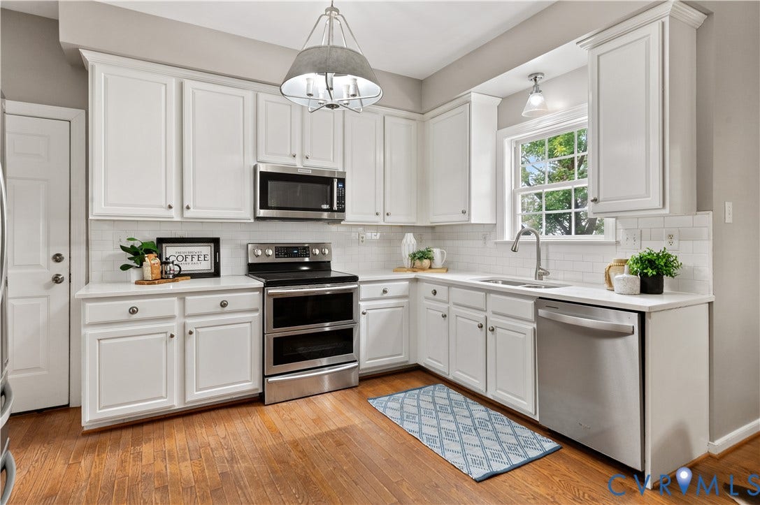 5117 Hart Mill Drive, Glen Allen, VA 23060 Kitchen featuring wood-finish flooring, white cabinetry, a subway tile backsplash, and stainless steel appliances including a microwave, range, and dishwasher