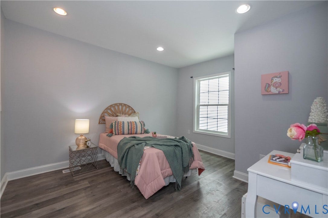 1209 N 22nd Street, Church Hill, Richmond, VA 23223 Recessed lighting illuminates this room featuring wood-finish flooring, a white window frame with blinds, and light gray wall paint