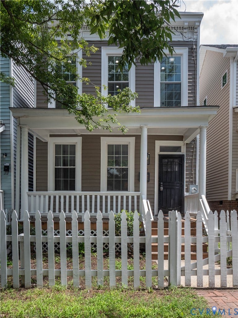 1209 N 22nd Street, Church Hill, Richmond, VA 23223 Two-story residence featuring a covered front porch with white columns, a picket fence with a gate, and horizontal siding