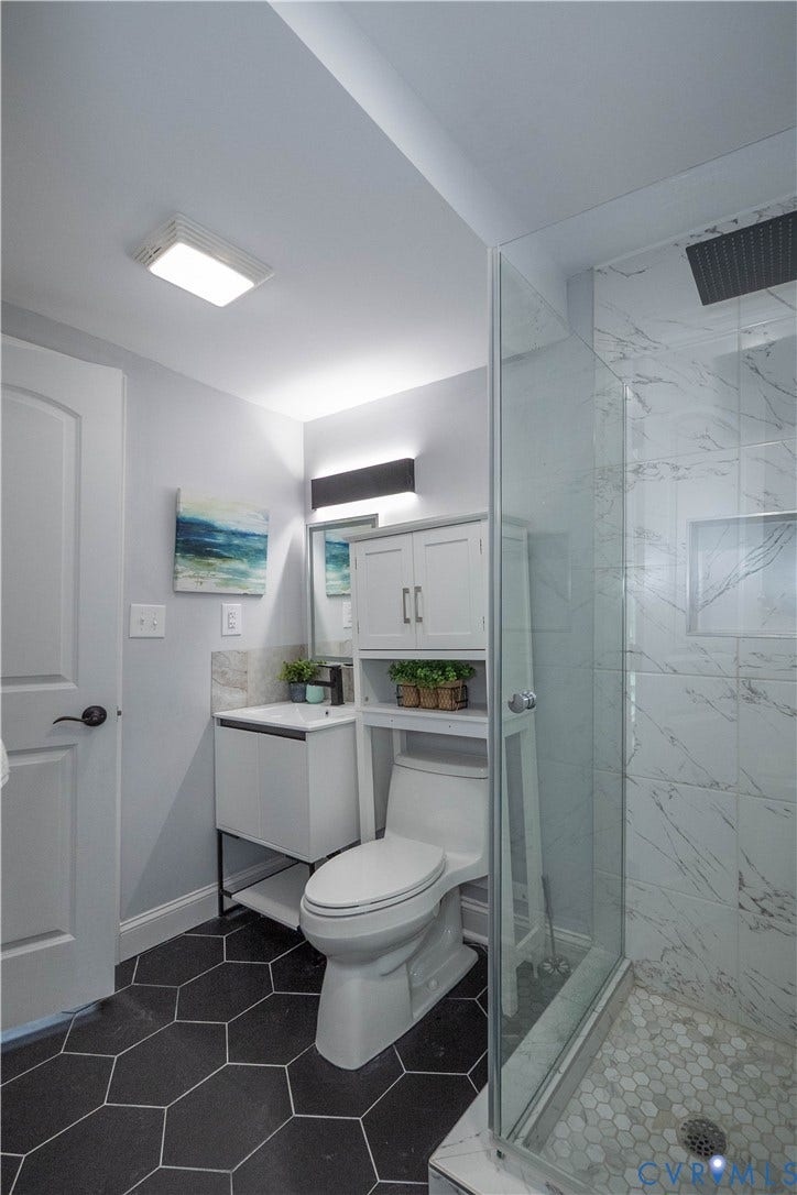 1209 N 22nd Street, Church Hill, Richmond, VA 23223 Bathroom featuring a glass-enclosed shower with white marble-look wall tiling and a white hexagonal floor