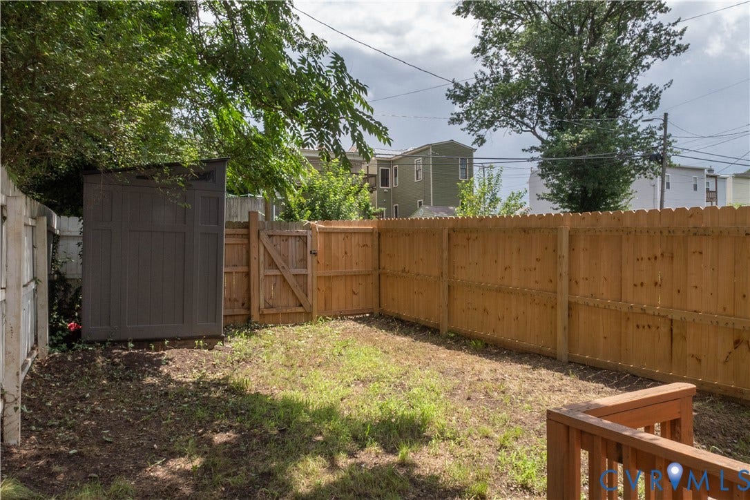 1209 N 22nd Street, Church Hill, Richmond, VA 23223 Private backyard space featuring a wood privacy fence, a wooden gate, and a storage shed