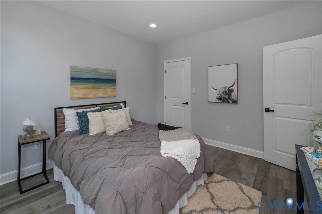 1209 N 22nd Street, Church Hill, Richmond, VA 23223 Spacious room featuring light gray walls, wood-finish flooring, recessed lighting, and white paneled doors with matte black hardware