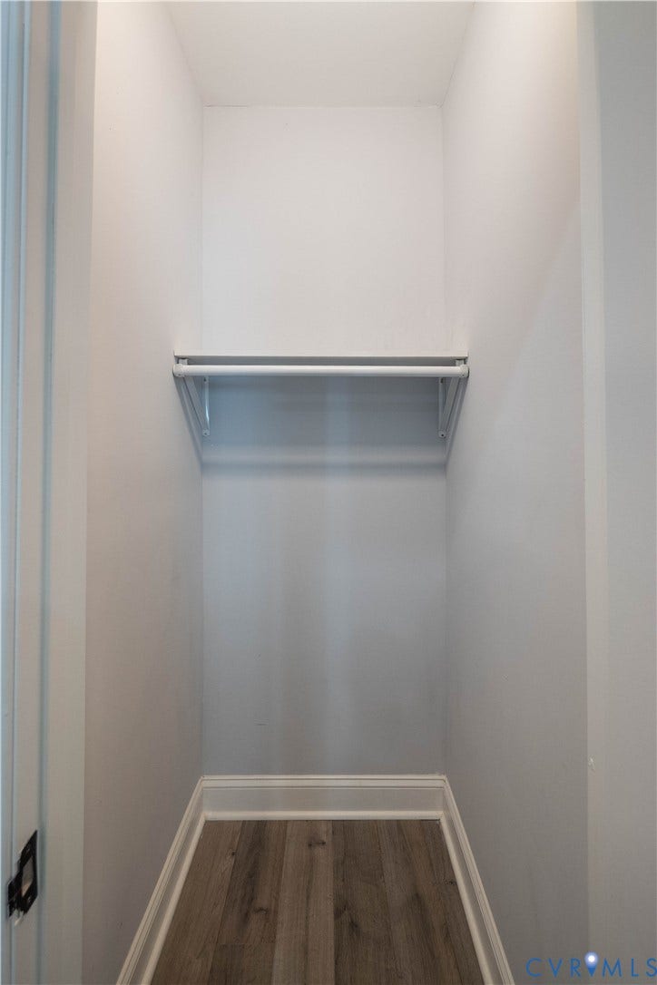 1209 N 22nd Street, Church Hill, Richmond, VA 23223 Compact closet featuring a hanging rod and upper shelf, wood-finish flooring, white baseboards, and light-toned walls