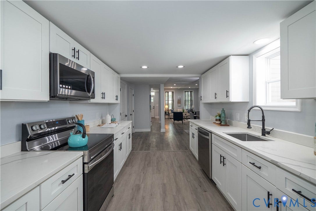 1209 N 22nd Street, Church Hill, Richmond, VA 23223 Galley kitchen featuring white shaker cabinetry, stainless steel appliances, light-toned countertops, wood-finish flooring, and a window above the sink