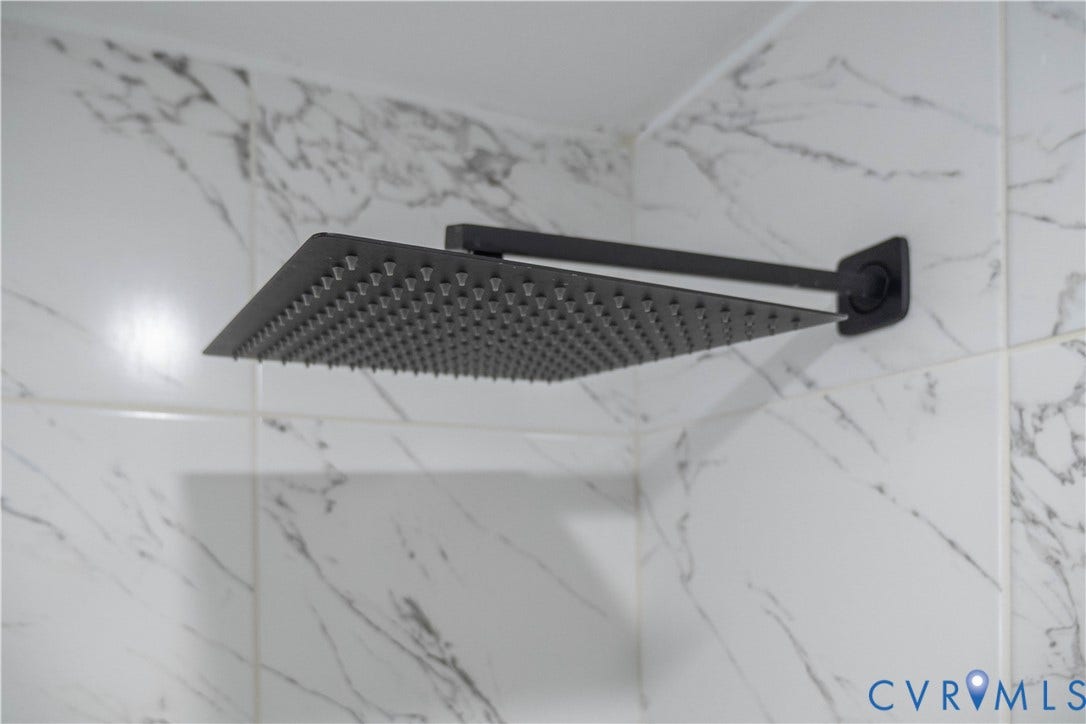 1209 N 22nd Street, Church Hill, Richmond, VA 23223 Matte black rainfall showerhead with a square design, mounted against white tile featuring gray veining