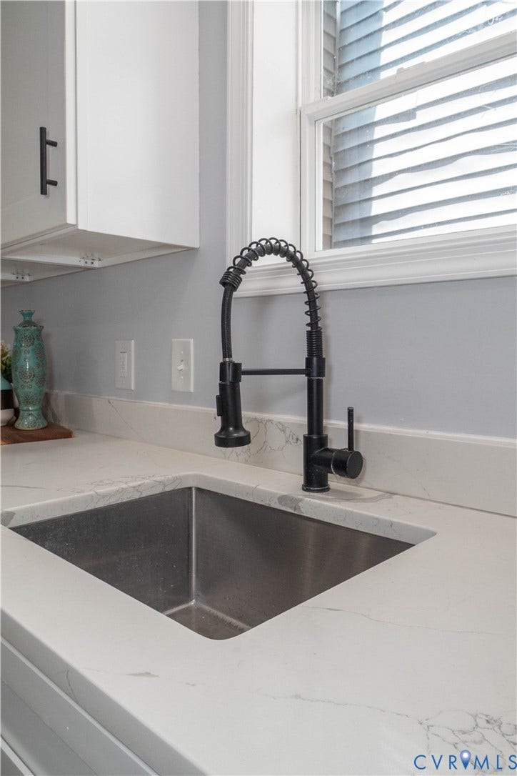 1209 N 22nd Street, Church Hill, Richmond, VA 23223 Stainless steel undermount sink with a matte black high-arc faucet, set into a white countertop with subtle veining