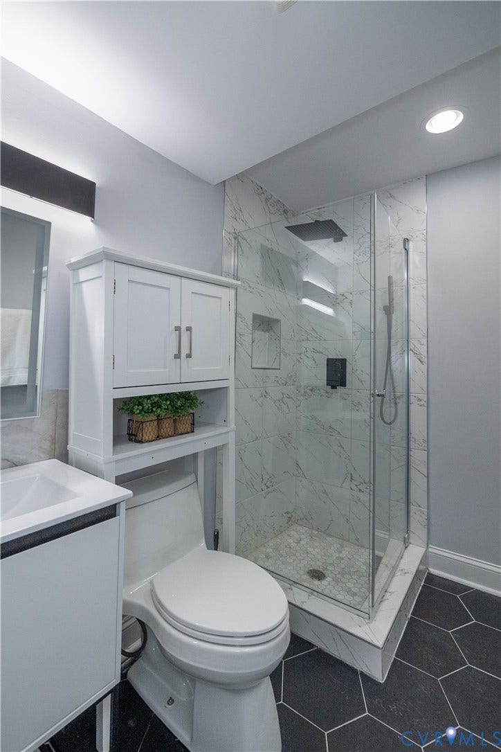 1209 N 22nd Street, Church Hill, Richmond, VA 23223 Bathroom featuring a walk-in shower with a glass enclosure, marble-look tile surround, and a matte black rainfall showerhead