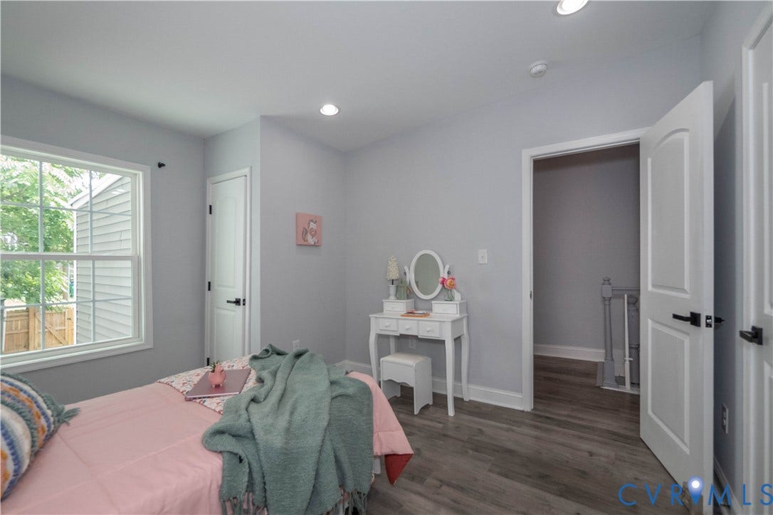 1209 N 22nd Street, Church Hill, Richmond, VA 23223 Room featuring light gray walls, wood-finish flooring, a double-hung window with white trim, a solid white door with black hardware, and recessed ceiling lighting