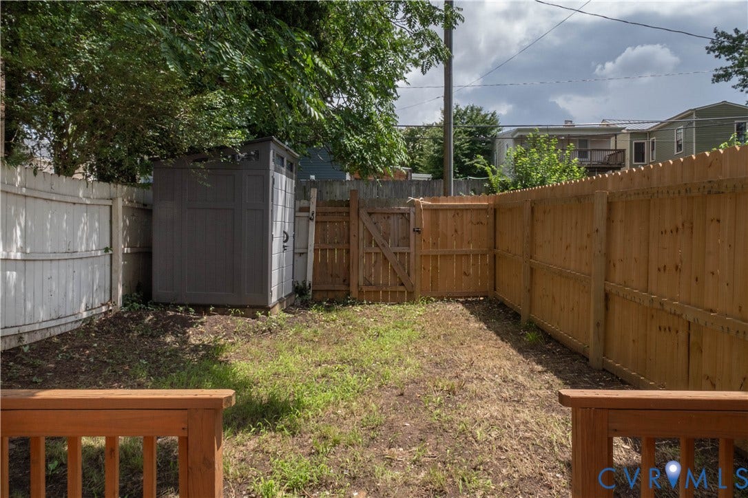 1209 N 22nd Street, Church Hill, Richmond, VA 23223 Backyard area featuring a new wood privacy fence, a gray storage shed, a wood gate, and a wood deck railing