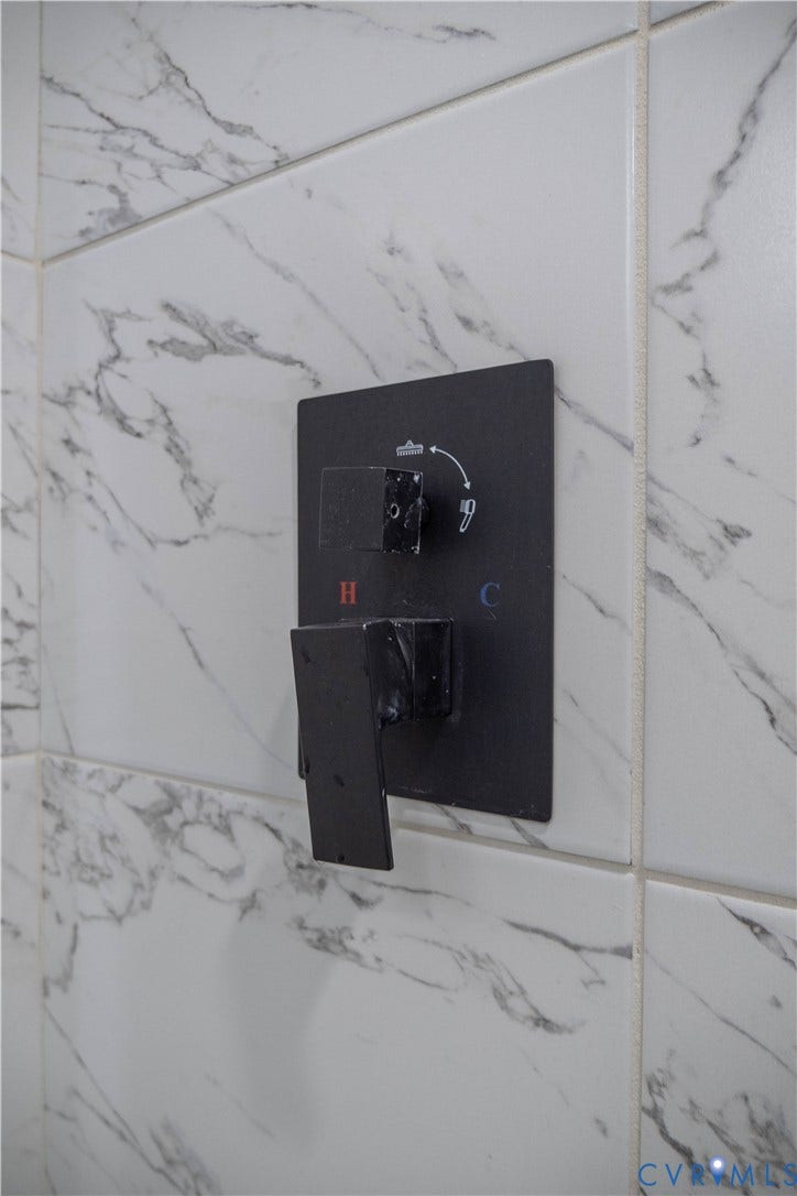 1209 N 22nd Street, Church Hill, Richmond, VA 23223 Shower control featuring a matte black finish against large-format white tile with gray veining