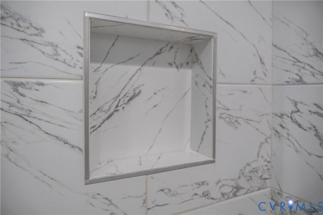 1209 N 22nd Street, Church Hill, Richmond, VA 23223 Recessed niche with a brushed metal trim set within white tiling featuring prominent gray veining