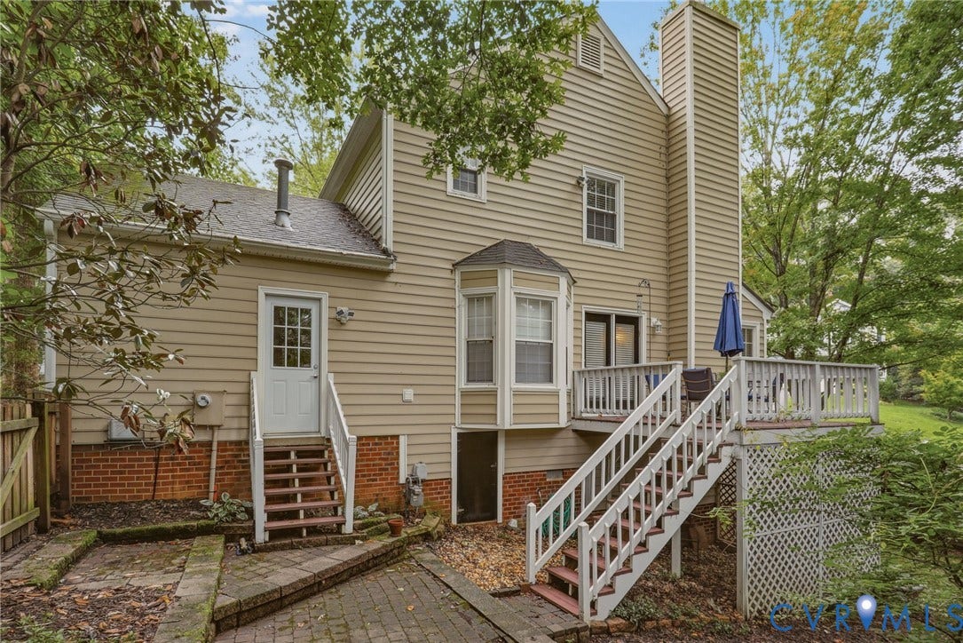 Deck leads to paver patio and fenced backyard