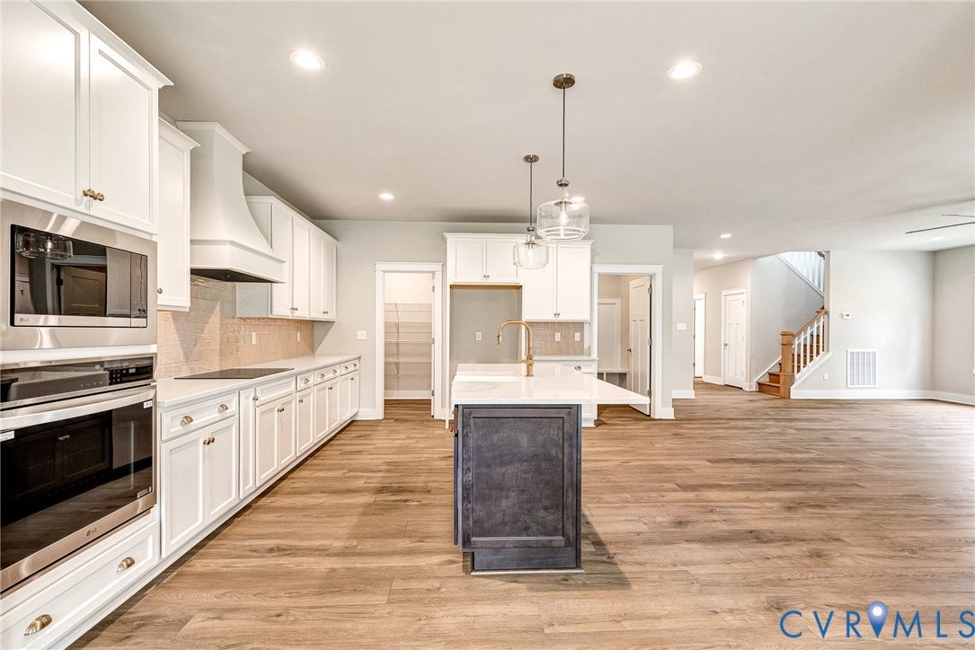 11101 Somerset Hill Drive, Somerset Hills, Glen Allen, VA 23059 Open-concept kitchen with white shaker cabinetry, stainless steel appliances, a center island with pendant lighting, and wood-finish flooring