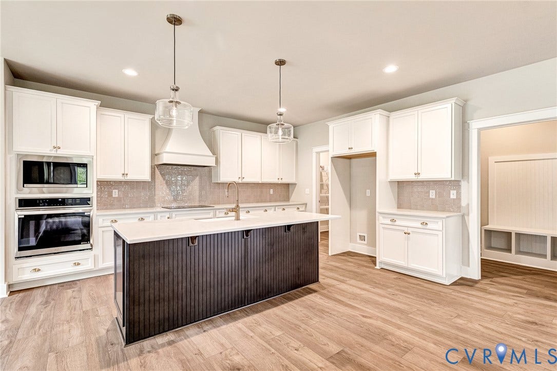 11101 Somerset Hill Drive, Somerset Hills, Glen Allen, VA 23059 White cabinetry, stainless steel appliances, wood-finish flooring, central island with dark paneling, and built-in bench seating