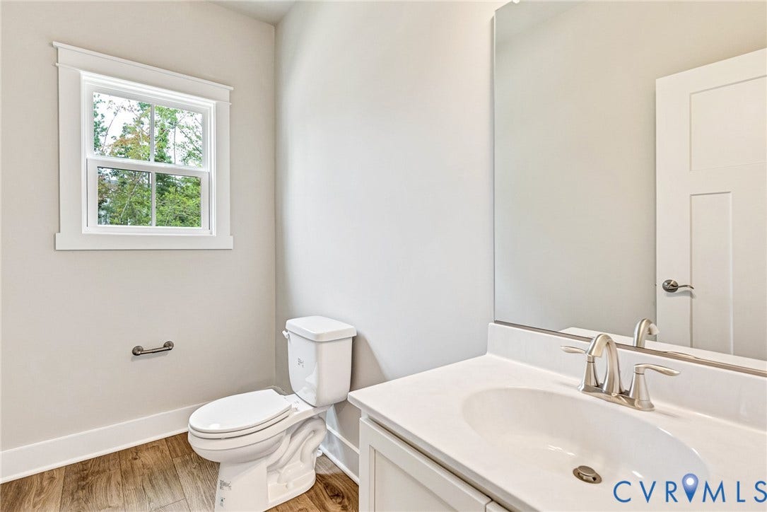 11101 Somerset Hill Drive, Somerset Hills, Glen Allen, VA 23059 Bathroom featuring a single-pane window, wood-finish flooring, a white vanity with an undermount sink, a chrome faucet, and a large wall-mounted mirror