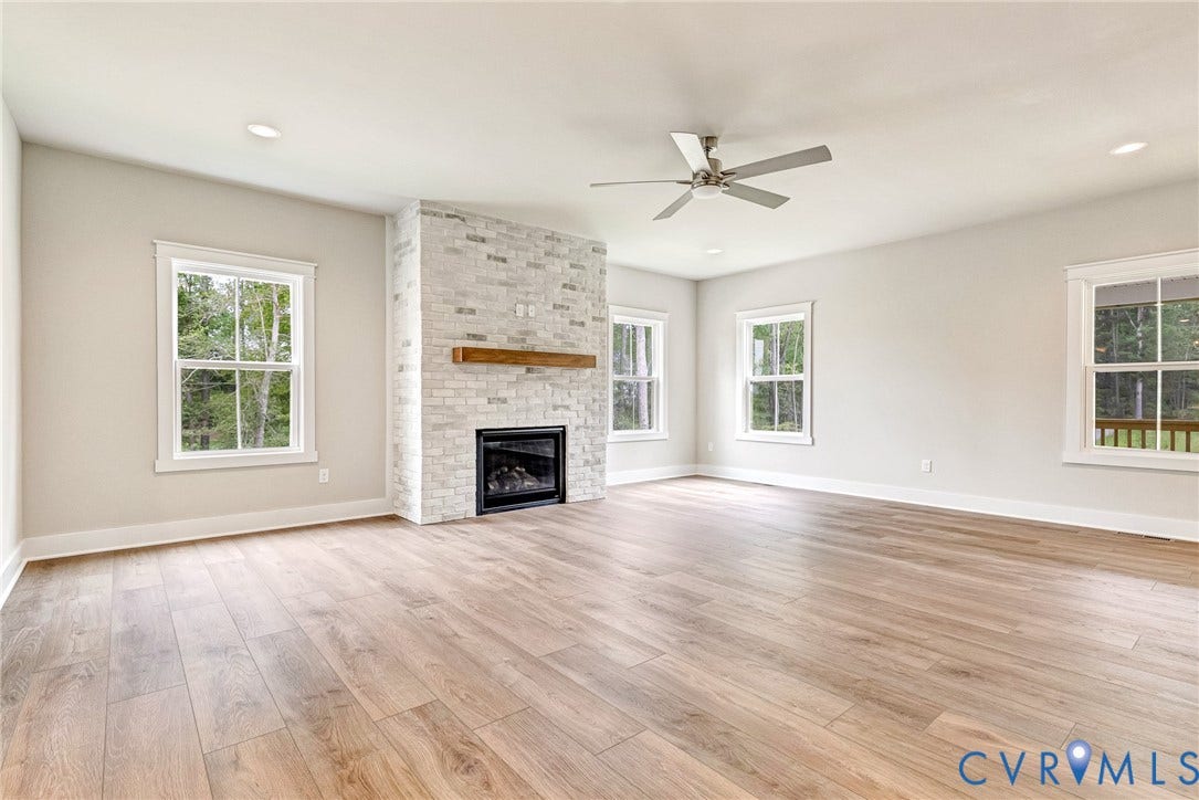 11101 Somerset Hill Drive, Somerset Hills, Glen Allen, VA 23059 Spacious living area featuring wood-finish flooring, a stone-clad fireplace with a wood mantel, multiple windows, and recessed lighting