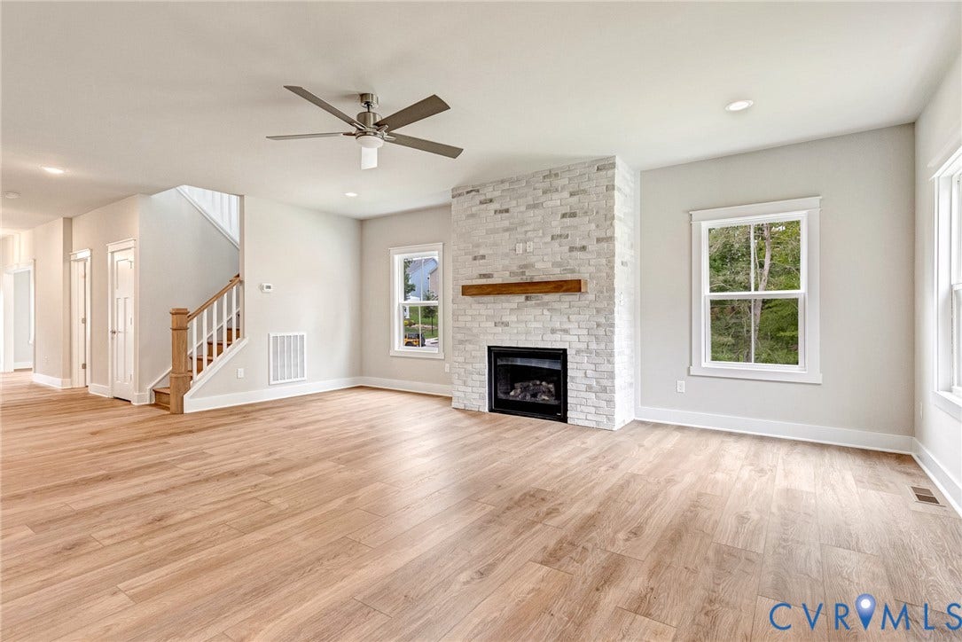 11101 Somerset Hill Drive, Somerset Hills, Glen Allen, VA 23059 Wood-finish flooring, white brick fireplace with a wood mantel, ceiling fan, recessed lighting, and a staircase with wood newel posts and handrail