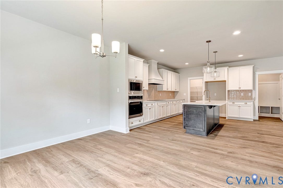 11101 Somerset Hill Drive, Somerset Hills, Glen Allen, VA 23059 Spacious room featuring wood-finish flooring, a kitchen with white cabinetry, a central island with a contrasting base, recessed lighting, and a contemporary chandelier