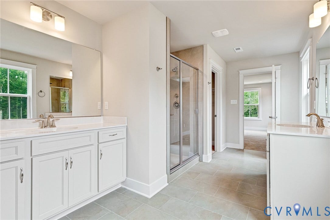 11101 Somerset Hill Drive, Somerset Hills, Glen Allen, VA 23059 Dual vanity with white cabinetry and integrated sinks, glass-enclosed shower, tile flooring, and multiple windows
