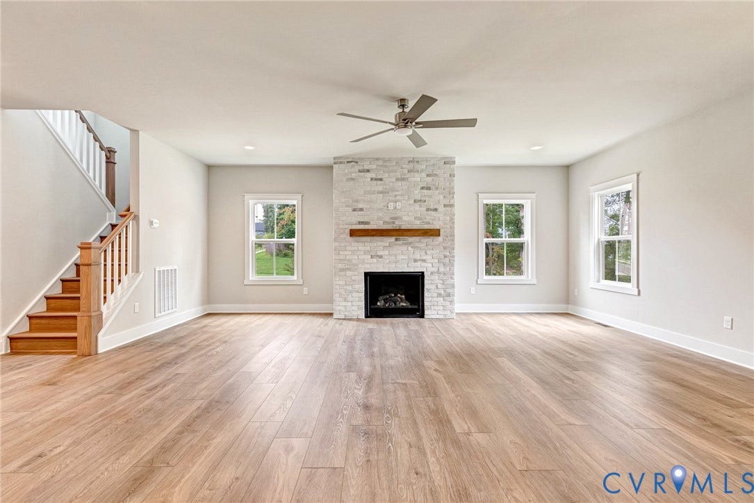 11101 Somerset Hill Drive, Somerset Hills, Glen Allen, VA 23059 Spacious living area featuring wood-finish flooring, a stone-clad fireplace with a wood mantel, multiple windows, recessed lighting, and a ceiling fan