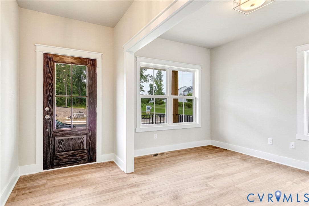 11101 Somerset Hill Drive, Somerset Hills, Glen Allen, VA 23059 Wood-finish flooring, dark wood-panel door with glass inserts, white trim, multiple pane windows, and a flush mount ceiling light