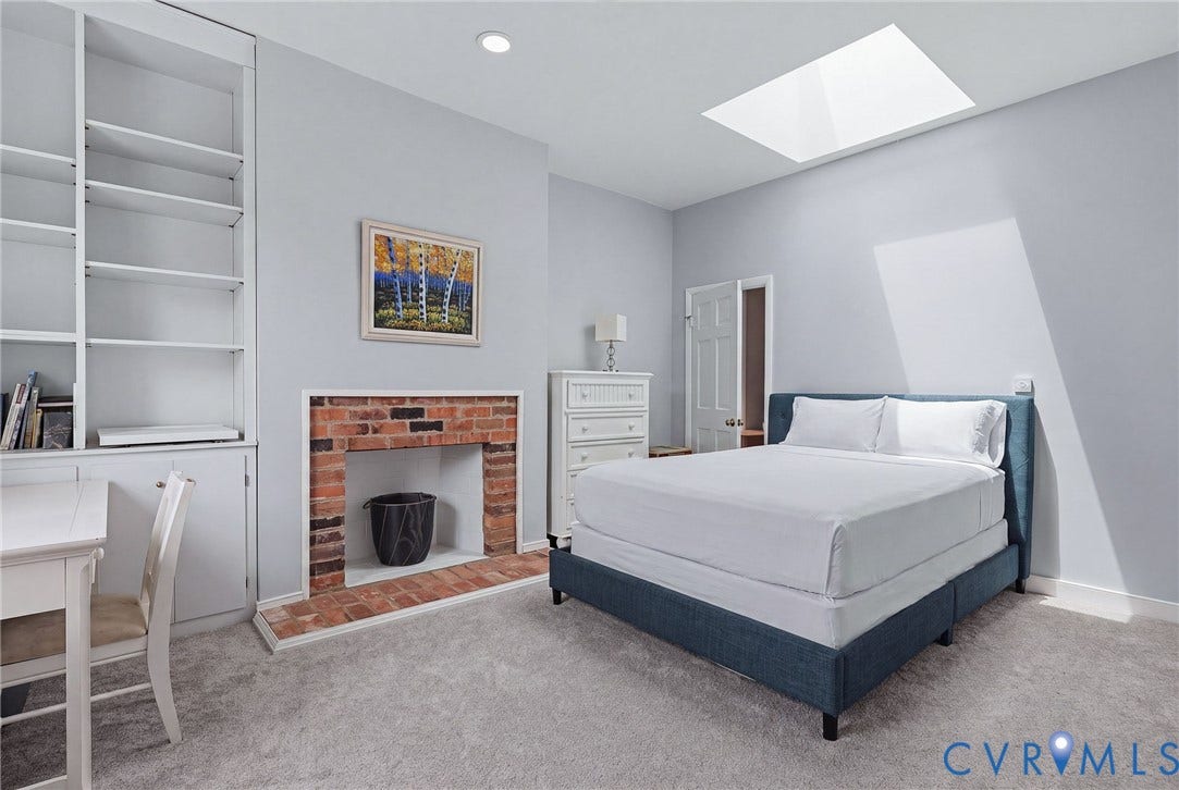 404 N Shields Avenue, Richmond, VA 23220 Bedroom featuring a large ceiling skylight, built-in shelving, brick-surround fireplace, recessed lighting, and light-tone carpeting