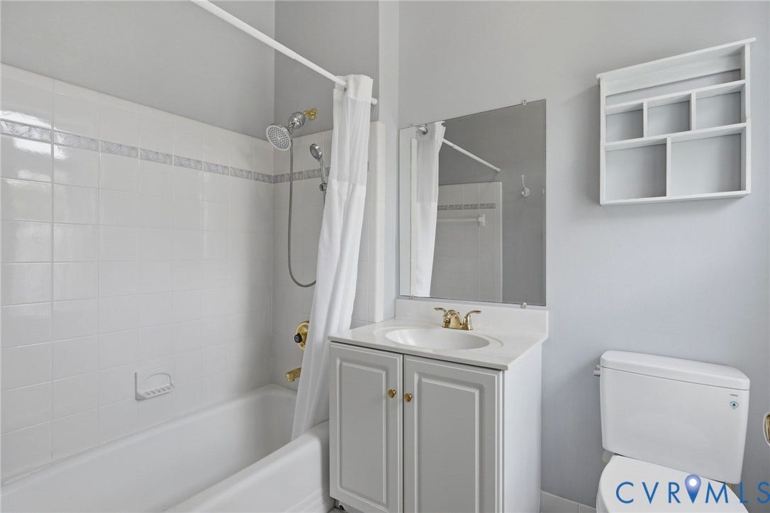 404 N Shields Avenue, Richmond, VA 23220 Bathroom featuring a white vanity with a single sink, an integrated mirror, and a built-in wall shelf