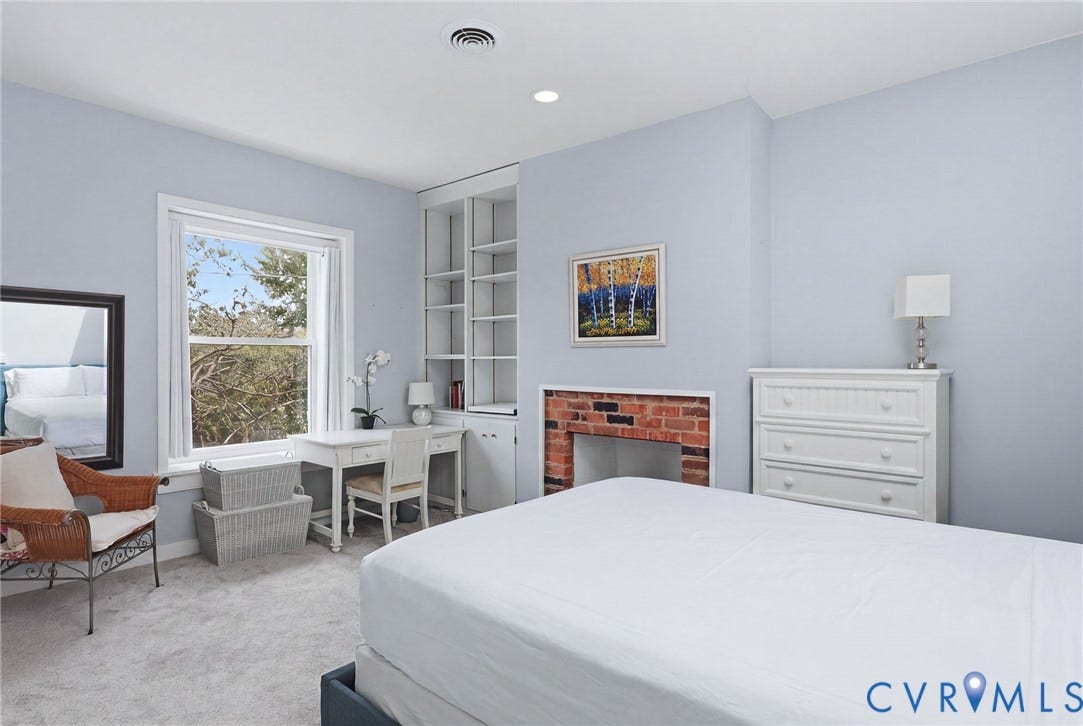 404 N Shields Avenue, Richmond, VA 23220 Bedroom featuring light gray wall paint, a single window, built-in shelving, a brick fireplace surround, and soft gray carpeting