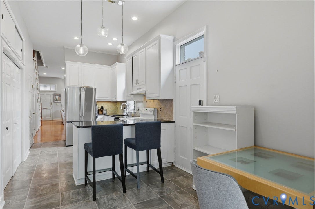 404 N Shields Avenue, Richmond, VA 23220 Kitchen featuring white cabinetry, stainless steel appliances, a center island with bar seating, and pendant lighting